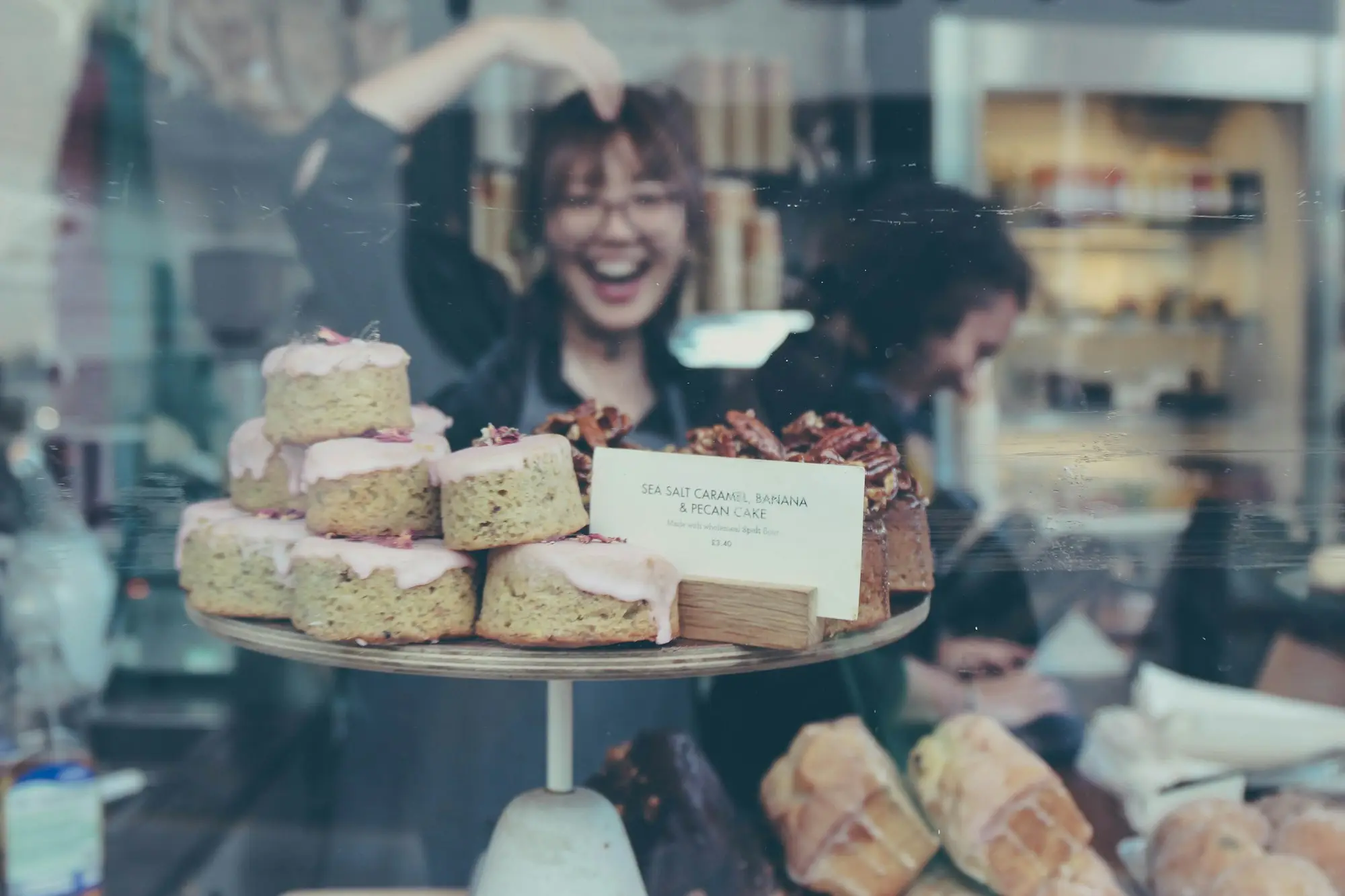 Smiling baker reflected in the display cabinet