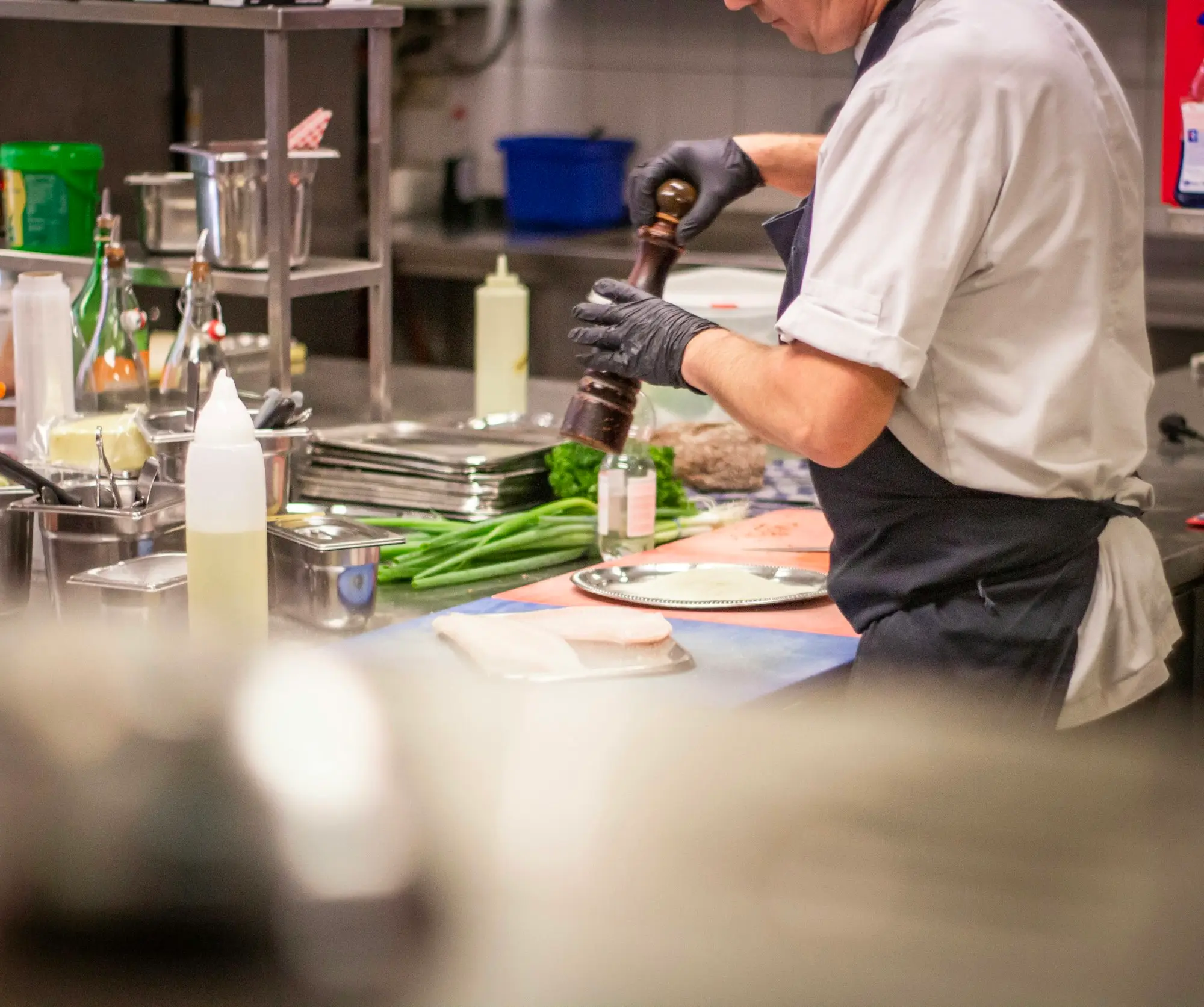 Chef finishing a plate with fresh herbs