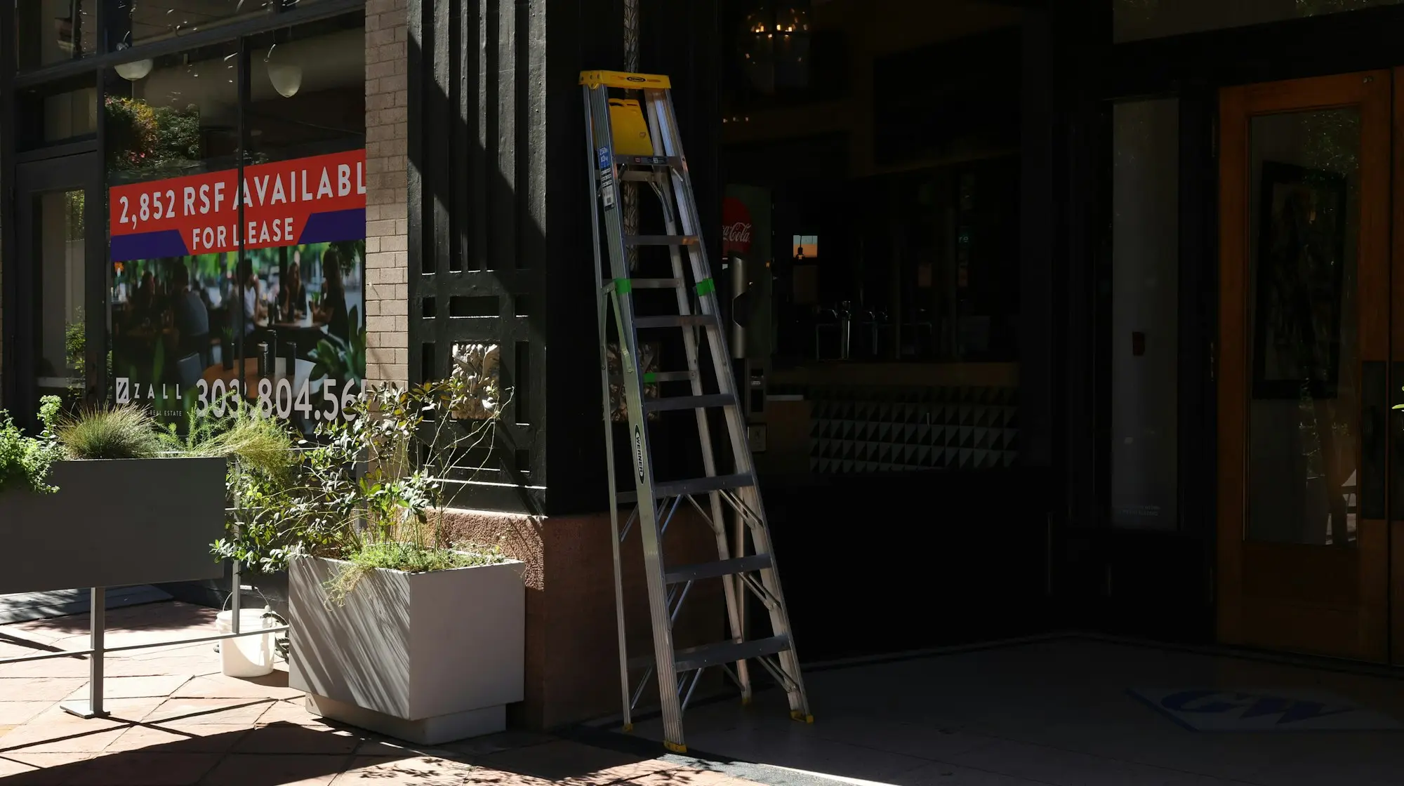 Building entrance with a for lease sign and a stepladder