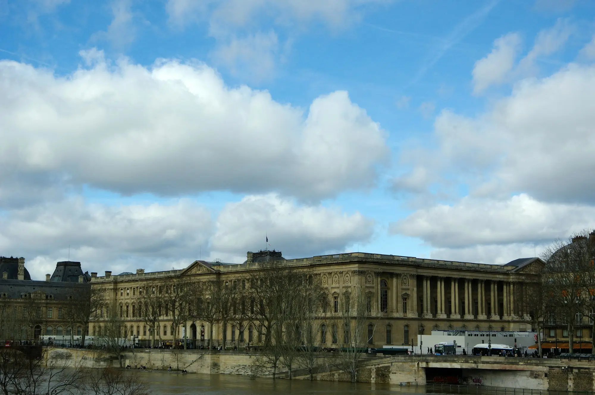 A grand building with columns beside a river