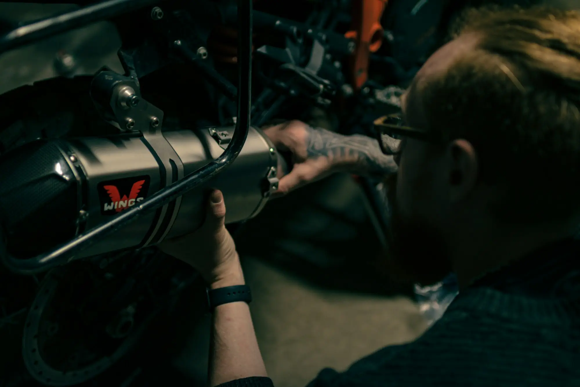 Mechanic working on a motorbike with a spanner