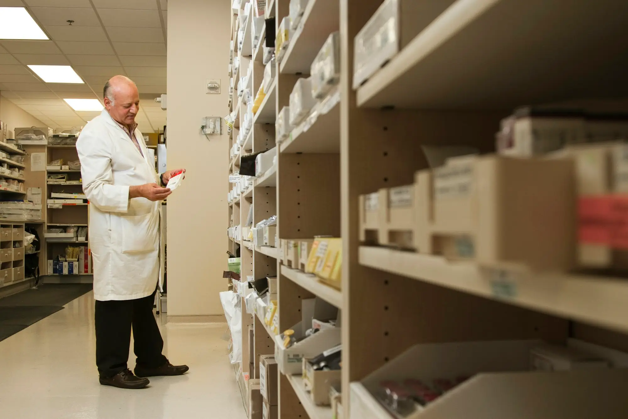 Pharmacist standing near the pharmacy shelves