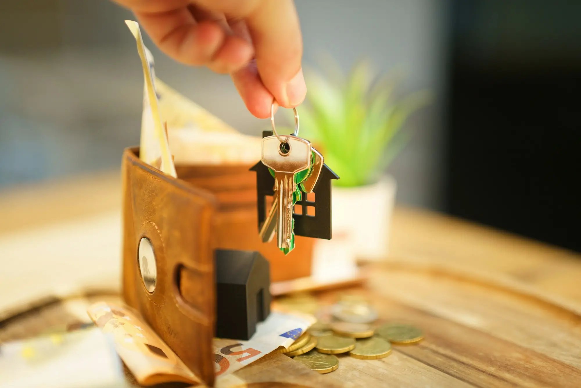 Hand holding keys with a house charm